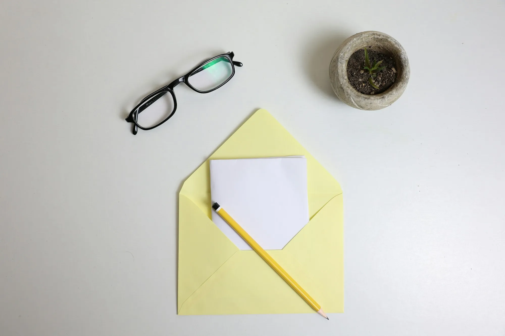 Reading glasses and a pencil resting on a sealed envelope